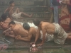 Devotees come to take a bath in the river by rolling on the ground